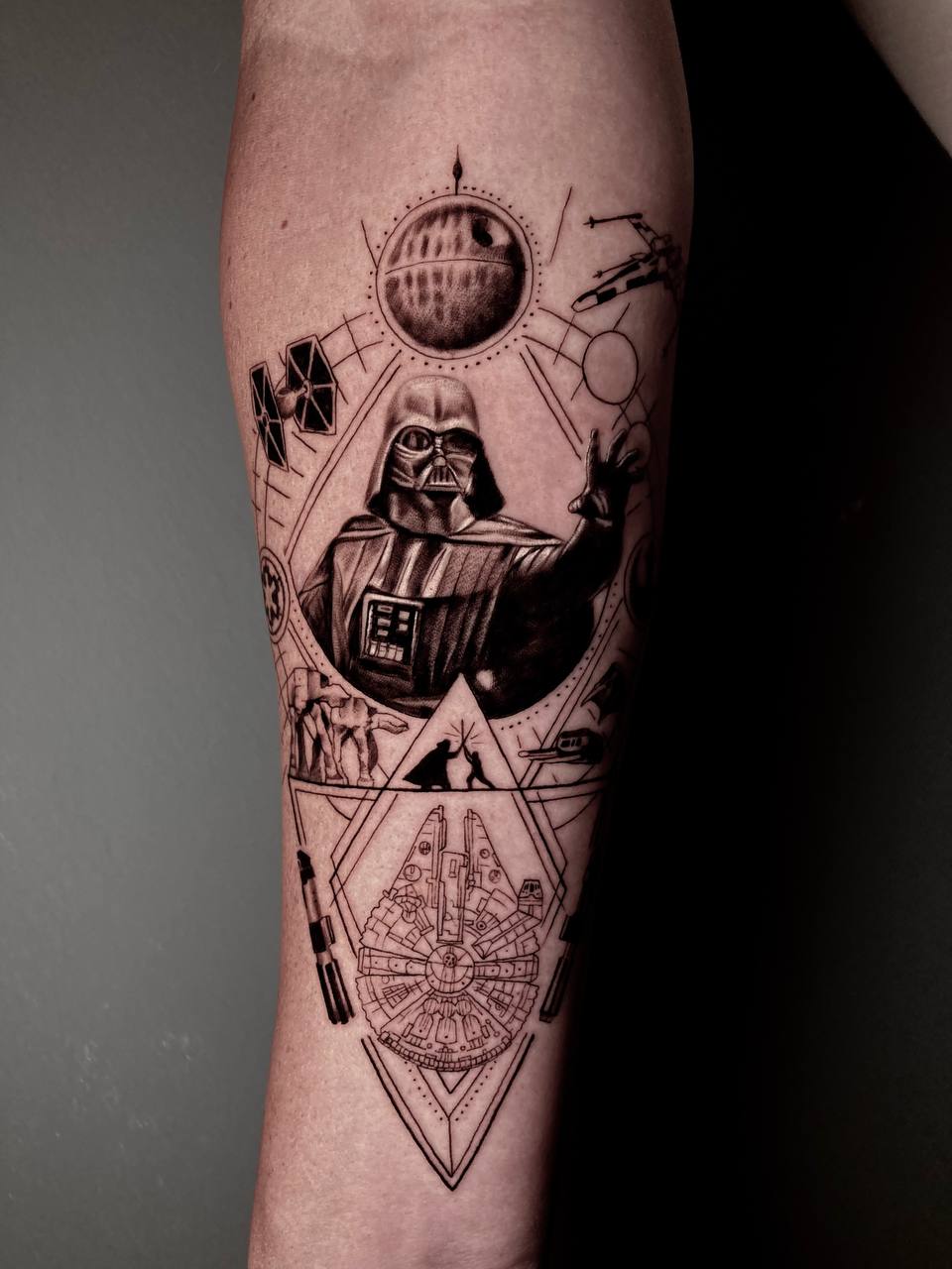 Tattoo von Darth Vader in Schwarz, umgeben von Raumschiffen und geometrischen Formen.